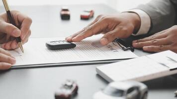 Two people signing a contract with a car key video