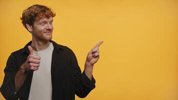 Smiling Man Giving Thumbs Up and Pointing on Yellow Background video