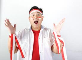 Excited Indonesian Man wearing red and white headband with both hands open and mouth open saying WOW photo