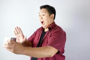 Man showing rejection gesture with his hand when holding a metal box, mouth open saying NO photo