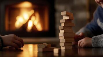 Two children playing with wooden blocks in front of a fireplace photo