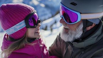 An older man and young girl are smiling while wearing ski goggles photo