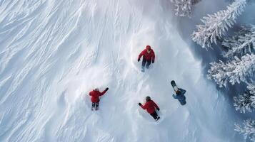 Four people are riding snowboards down a snowy slope photo