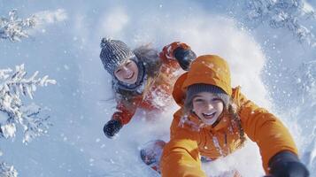 Two people in orange jackets riding snowboards down a hill photo