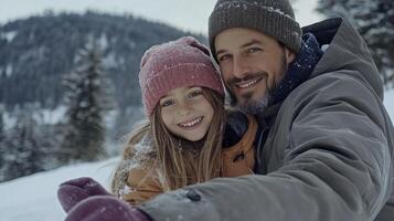 A man and a little girl are taking a selfie in the snow photo