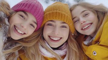 Three girls in winter clothing smiling for the camera photo