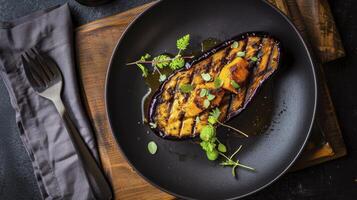 Grilled eggplant with herbs on a black plate photo