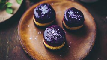 Three purple desserts on a wooden plate photo