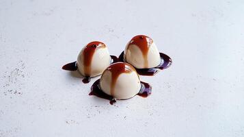 Three dessert balls with caramel sauce on top photo
