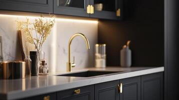 A black kitchen with gold fixtures and marble countertops photo
