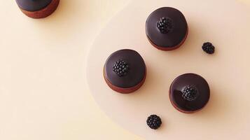Four chocolate covered donuts with blackberries on top photo