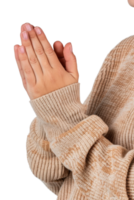 Person with clasped hands in a cozy beige sweater expressing gratitude and reflection in a warm, intimate setting png