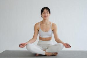 Yoga mindfulness meditation. Healthy woman practicing yoga isolated on white background. Woman sitting in lotus pose meditating relaxing. Girl doing breathing practice. Yoga on white background photo