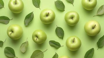 Green apples pattern with leaves on green background, top view photo