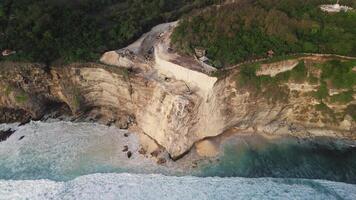 Engineering on rock cliff coastline in Uluwatu, Bali. Drone view video