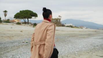 On the Beach A Woman In Brown Coat Walks With Sumptuous Classical Dance Move video