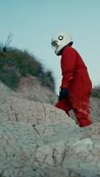 astronaute avec Orange costume et casque des promenades sur le rochers de une hostile planète video