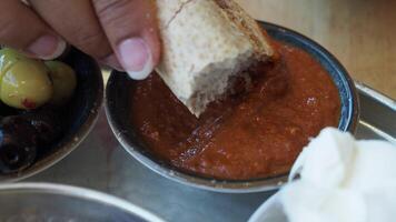 Dipping bread into savory sauce at local eatery in the afternoon video