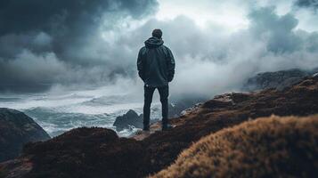 Contemplative figure overlooking a stormy sea, standing on a cliff, enveloped by moody skies and crashing waves. photo