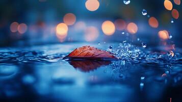 Autumn leaf rests serenely on a pond surface as droplets of rain cascade around it, reflecting city lights in a cool aquatic scene. photo