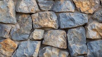 Rustic stone wall featuring a mix of gray and tan rocks, creating a rugged texture and natural pattern for backgrounds or architectural use. photo