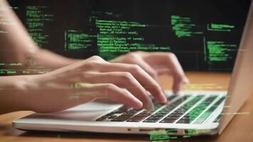 Person typing on a laptop keyboard with a green code overlay on a dark background on a wooden table video