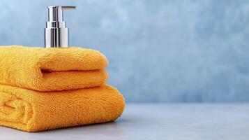 A stack of towels with a bottle of hand soap photo
