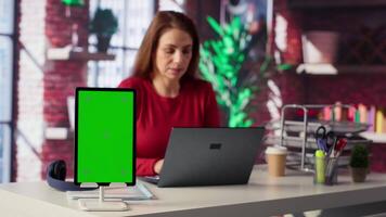 Person uses laptop for creative projects next to isolated copy space, creating designs while staying connected to the freelance platform. Woman focusing on research and multitasking. Camera A. video
