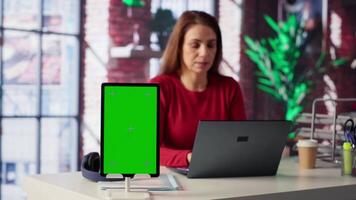Confident woman solving tasks on a freelance platform next to mockup screen, answering emails and multitasking. Person staying connected and enjoying flexibility of working from home. Camera A. video