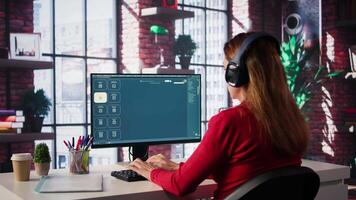 Mature developer coding cloud computing with AI chatbot on pc, working from her home and focuses on the software development process for productivity and innovation. Prompts for code. Camera B. video