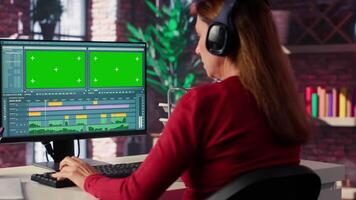 Woman filmmaker works on post production with mockup at home office, ensuring the editing timeline and color correction for shoot. Tech driven workspace showcases workflow. Camera A. video