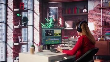 Focused editor woman works on montage in a creative software at home, digital media. Filmmaker using dual monitors to edit footage and create content, post production. Camera B. video