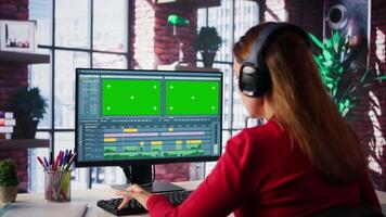 Focused editor woman works on montage next to copy space, creative software on desktop at home. Filmmaker using dual monitors to edit footage and create content, post production. Camera B. video