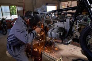 Anonymous technician working with welding machine while repairin photo