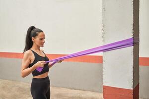 Sportswoman exercising with elastic band in gym photo