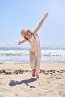 Cheerful boy running on beach with hands wide open like airplane photo