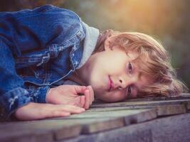 Boy lying on boardwalk and looking at camera photo