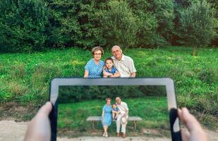 Grandparents and grandson posing for a picture with tablet photo