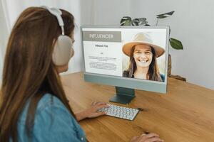 Female influencer using computer and browsing blog photo
