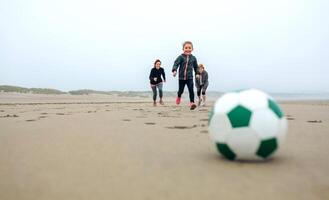 Soccer ball with three running people photo