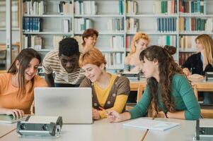 Diverse students discussing data on laptop photo