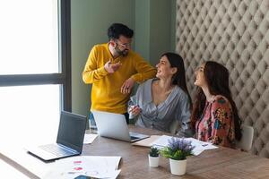 Joyful colleagues discussing project in modern workspace photo