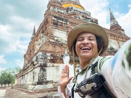 Joyous traveler with broad smile at ancient temple ruins, Ancient Temple Ruins Selfie photo