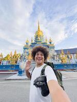 captures smartphone selfie with a colorful temple, Beaming Selfie with Colorful Temple photo