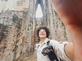 Joyful selfie capturing a traveler with smartphone and Buddha statue, Joyful selfie capturing a traveler with smartphone and Buddha statue photo