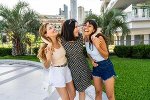 Portrait of three friends embracing together while laughing photo