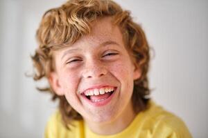 Happy boy with freckles on light background photo