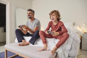 Happy man and child playing videogame at home photo