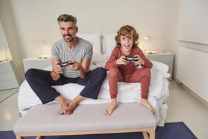 Excited father and son playing videogame photo