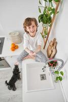 Smiling boy cleaning hands with soap on counter photo
